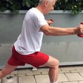 Nate Wilkins helping elderly aged with thighs stretching