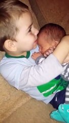 Little Boy Snuggles Newborn Baby Brother
