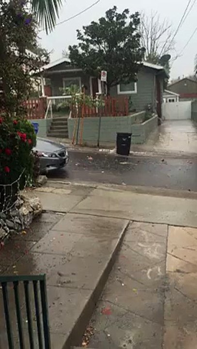 Trash Cans Slide down Street During Rain Storm
