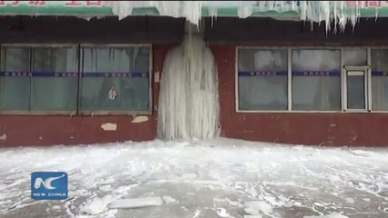Water heater leak in the cold winter frozens into an icefall outside a seven-floor building in Jilin