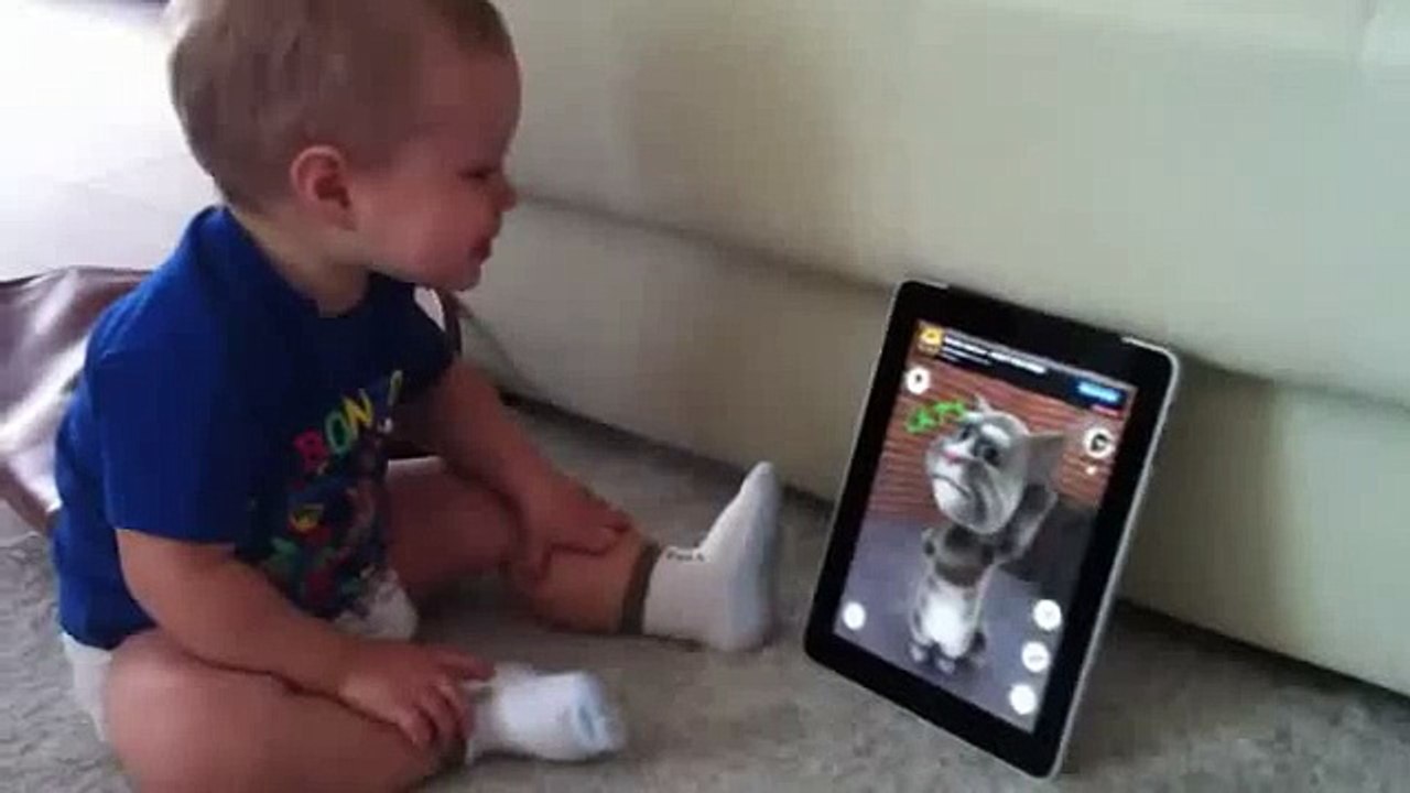 Funny baby talks with cat on iPad