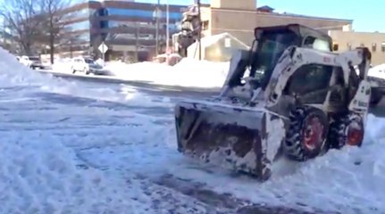 Arlington snowplow ballet amidst pedestrians, traffic