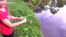 Young girl catches eel with tiny toy fishing rod