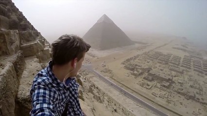 Un jeune homme grimpe au sommet de la Pyramide de Khéops