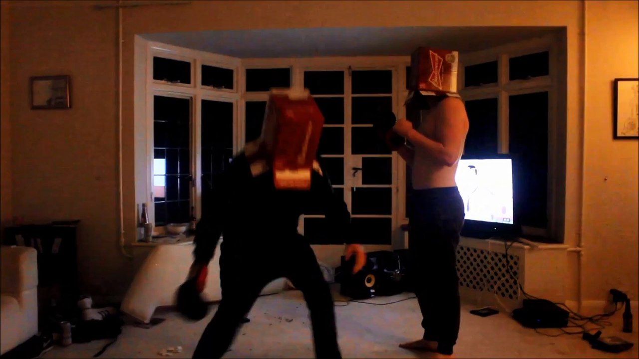 2 gars ivres se battent à l'aveugle avec des boites sur la tête