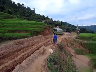 TATA Bus traverses a muddy dirt road in Nepal