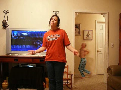 Funny Little Boy Dances behind His Sister