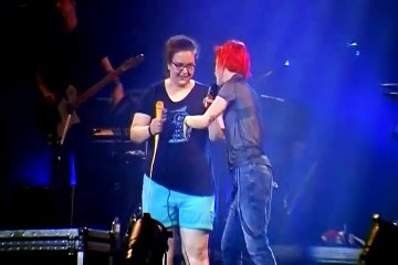 Une fan très excitée chante sur scène et chute en arrière: la réaction de son groupe préféré va surprendre toute la sall