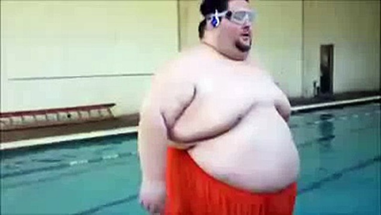 un gros qui saute dans une piscine