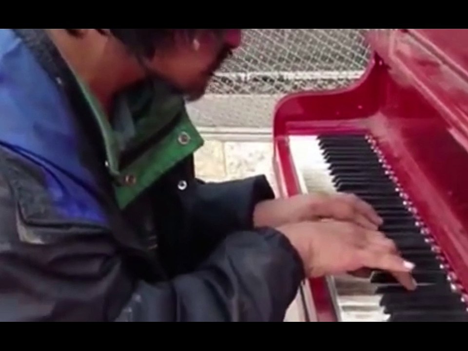 Бездомен човек свири на пияно.