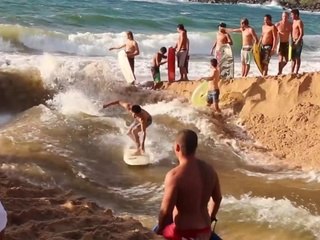 Des surfeurs créent une vague artificielle sur une plage à Hawaï