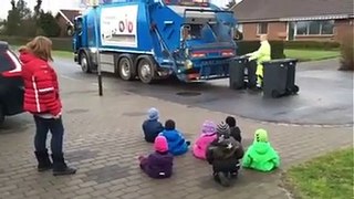 Des enfants regardent des éboueurs