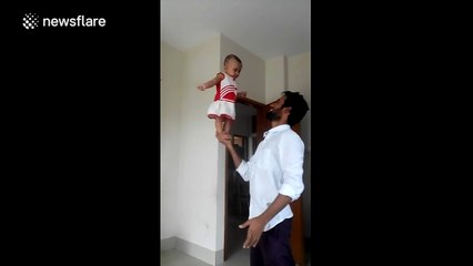 Man balances baby on his hand
