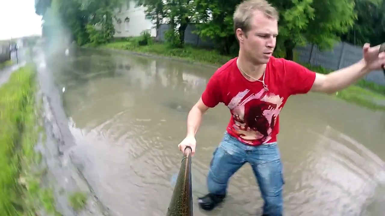 Un russe se fait tracter en snowboard par une voiture sur une route inondée