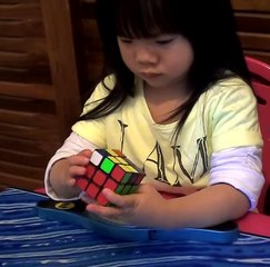 A little girl solving the Rubik’s Cube