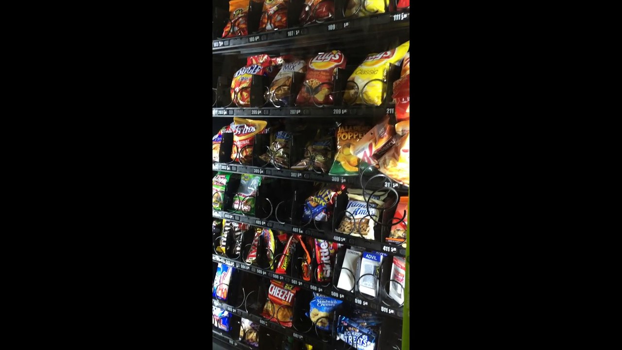 Des étudiants tentent de faire tomber les aliments bloqués dans le distributeur