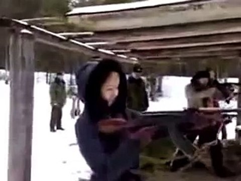 Блондинка стреляет из автомата.