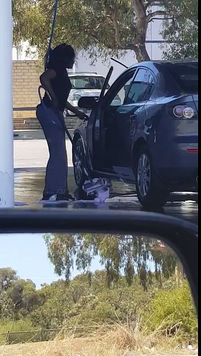 Dumb woman washing her car ... inside