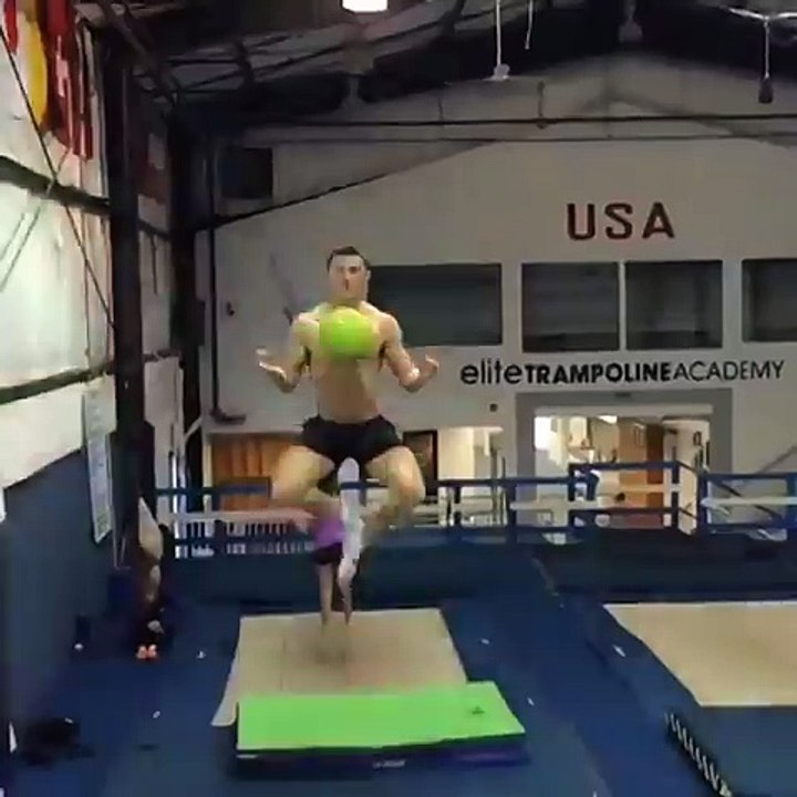 Guy Plays with Ball on Trampoline