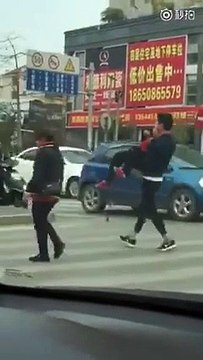 Il porte une mami qui a du mal à traverser un passage pour piétons. Beau geste !