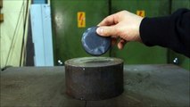 Un palet de hockey sur glace sous une presse hydraulique
