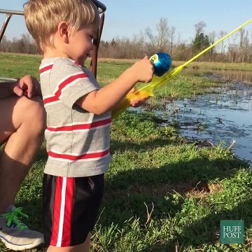 Un gamin attrape un gros poisson avec sa canne à pêche jouet.