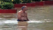 Crazy man swimming, diving and at the end falling in flooded street