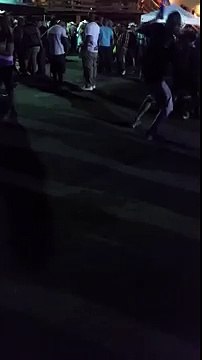 Guy throws a beer bottle into crowd.