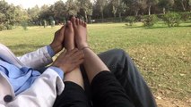 massaging Girl Friends foot in open park