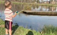 A 2 ans il pêche un poisson avec sa canne à pêche en plastique