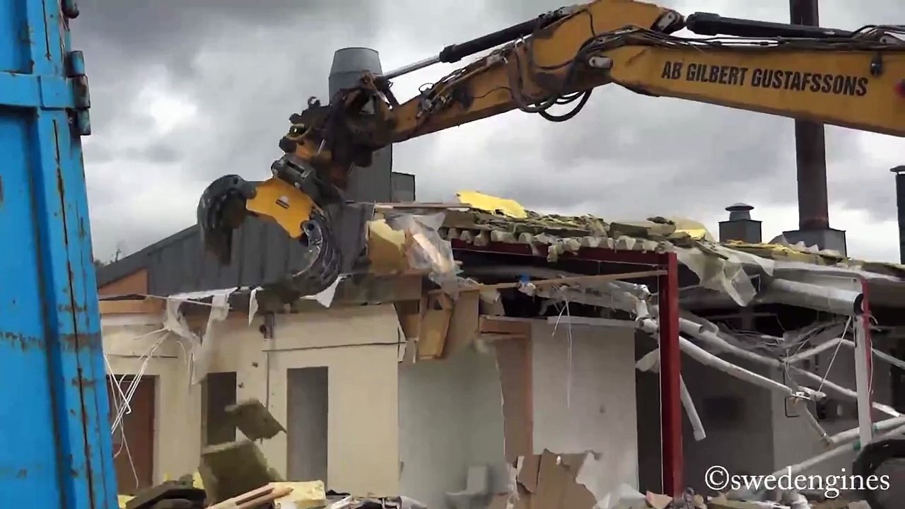 CAT 323DL demolishing a small building
