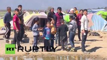 Greece- Farmer PLOUGHS land where refugees are living in tents