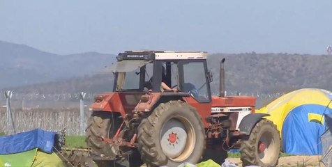 Greece: Farmer PLOUGHS land where refugees are living in tents