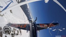 Un avion de voltige slalome dans un champ d'éoliennes