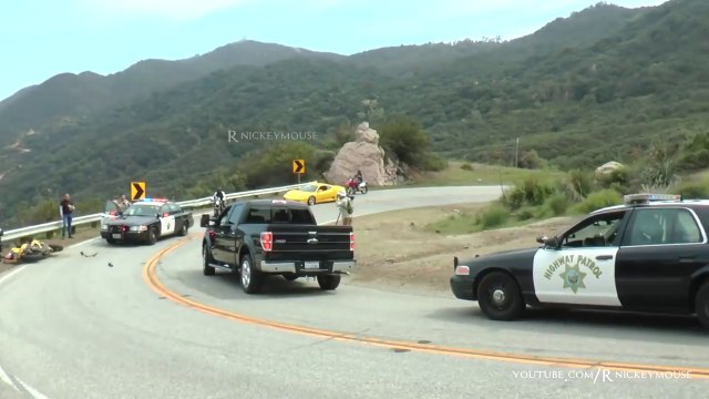 Un motard chute dans un virage juste devant une voiture de police