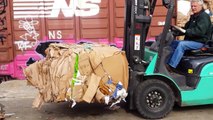 Finishing loading a train car with cardboard bales