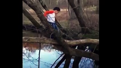 Little Boy Falls Off Log As He Crosses A River