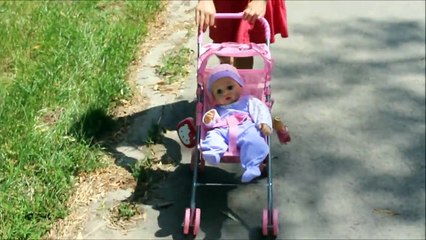 Toy baby doll outing to playground going for walk sitting on the swing sliding down slide