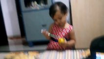 Acute baby drinking orange juice with a pencil