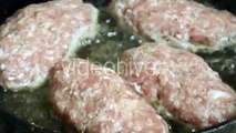 Pieces of Raw Minced Meat Lying on a Frying Pan in Boiling Oil
