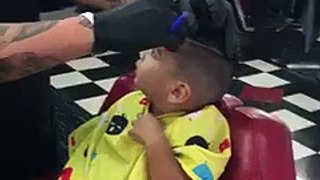 scary barber cutting hair of a brave child