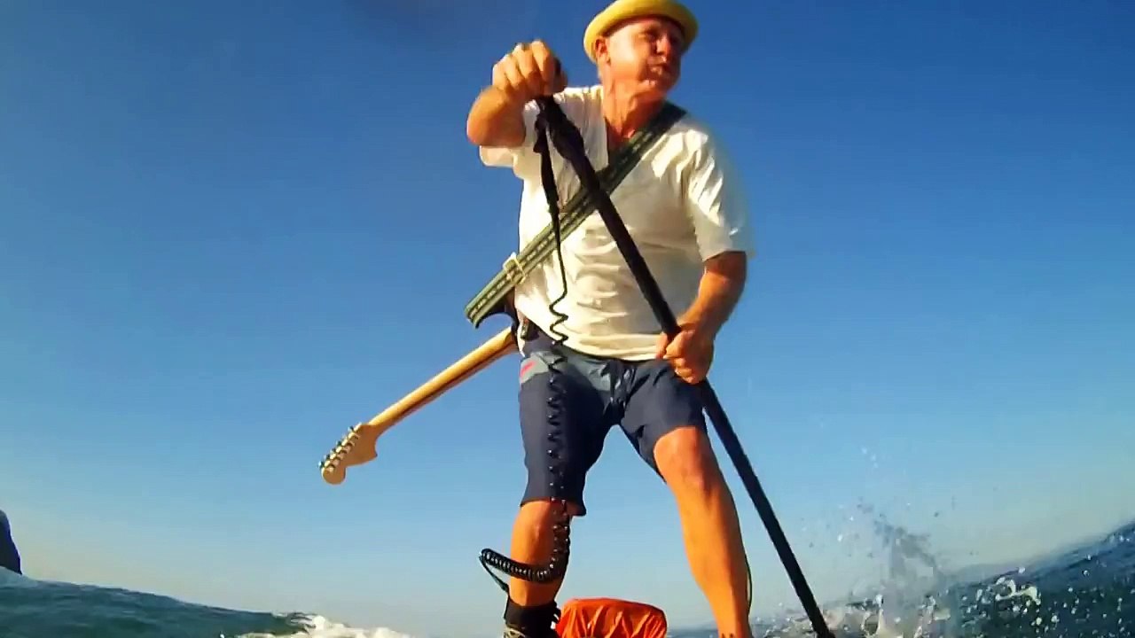 Il joue de la guitare électrique sur son paddle