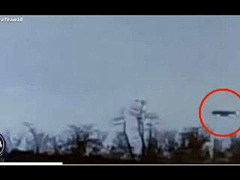 Spooked driver and daughter capture black 'flying saucer' UFO hovering above trees near busy road