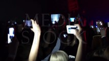 Party at a rock concert and hold cameras with digital displays