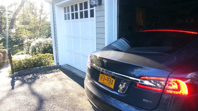 Un chien sort une voiture d'un garage pour son maitre !