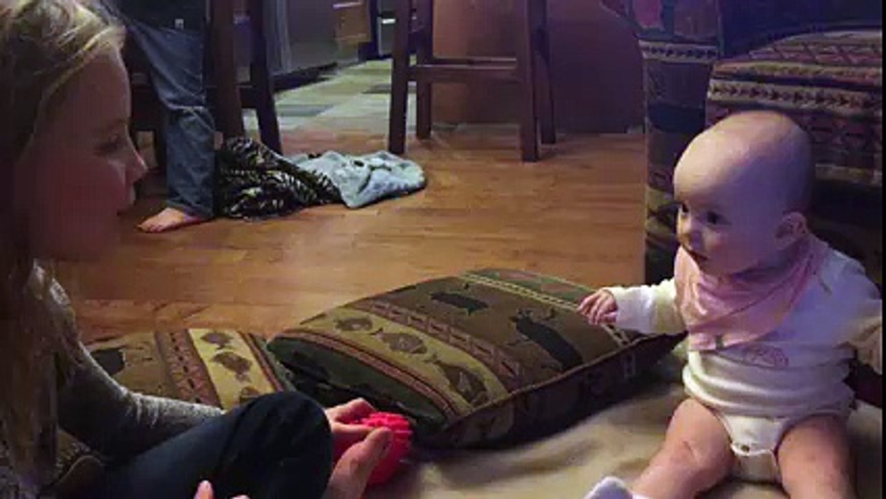 Un bébé fasciné par sa soeur qui fait des bulles de chewing gum