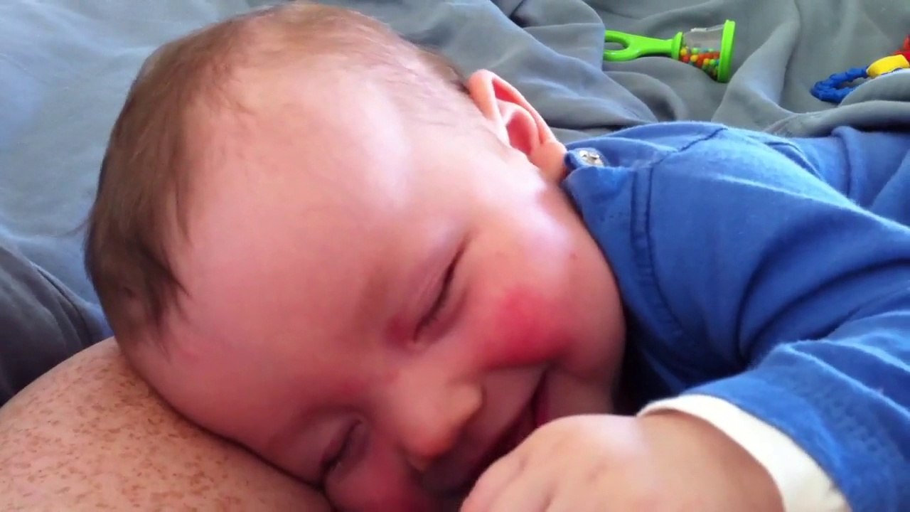 Um bebê ri dormindo