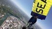 Un parachutiste filme son saut et son atterrissage dans un stade avant un match de foot US