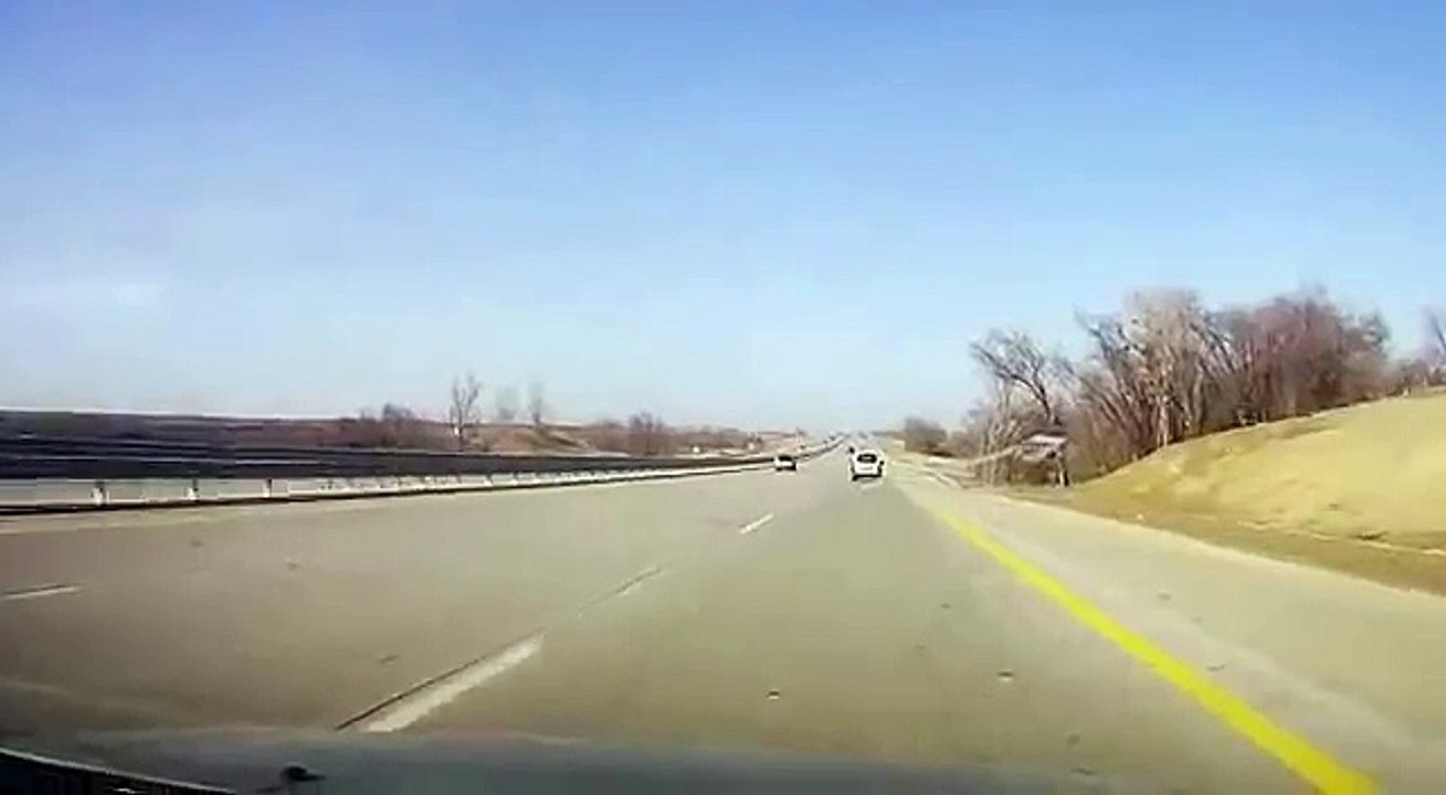 Ils change une roue sur la voie centrale d'une autoroute