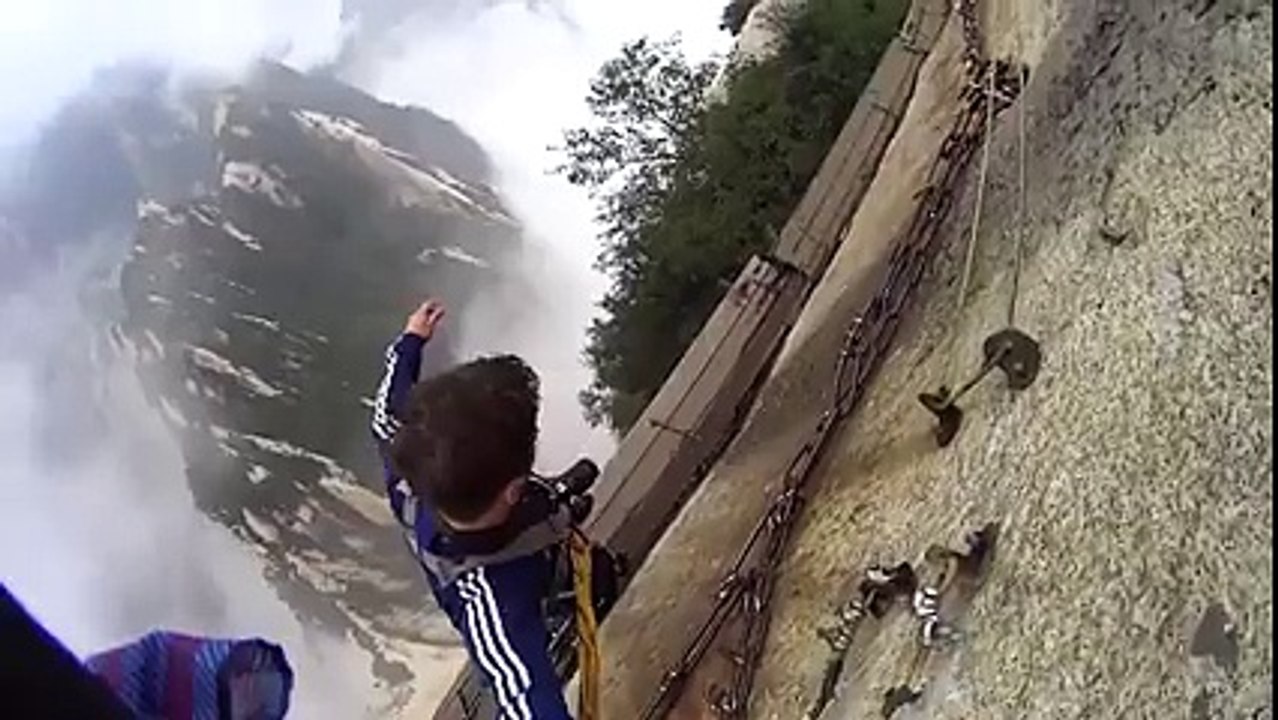 Il marche à flan de montagne sur de simples planches... Flippant